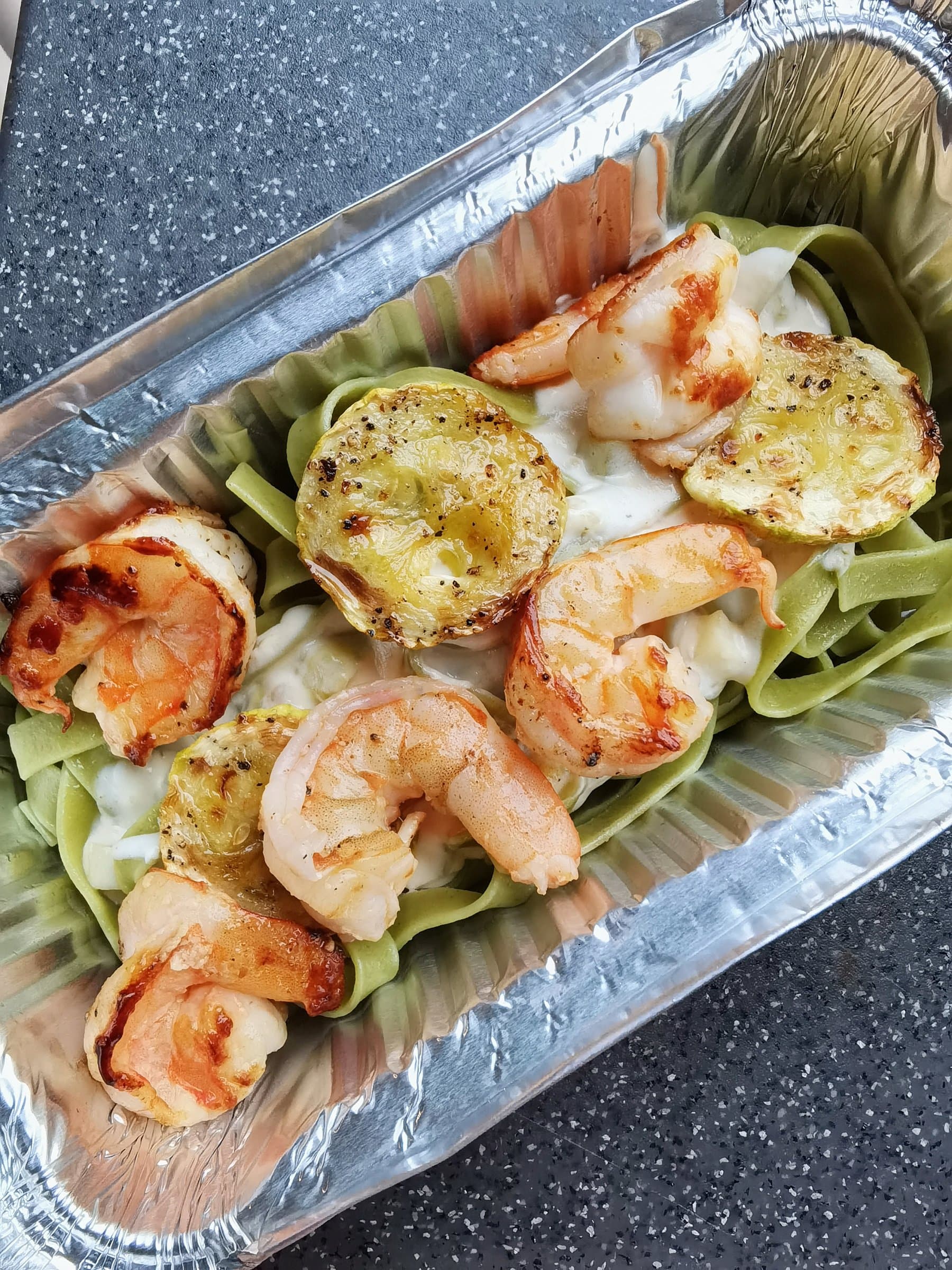 Shrimp served over pesto tagliatelle, a finished dish from a Wayfarer Zuevcheff cooking session